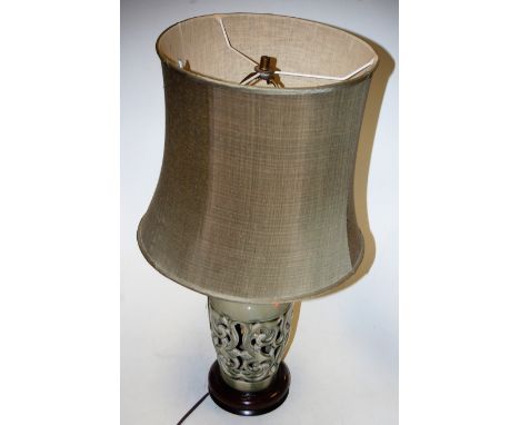 A modern green glazed reticulated table lamp, with matching silk shade, h.65cm