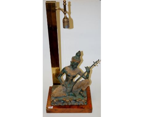 A contemporary table lamp, having a brass column to walnut base, the whole surmounted by a gilt metal figure of Buddha, h.77c