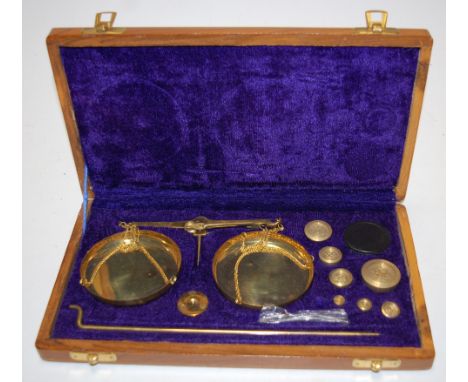 A cased set of brass balance scales and weights 
