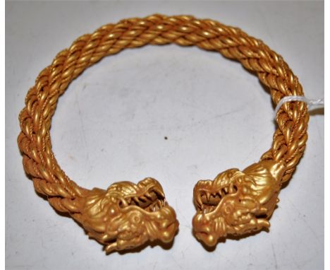 A modern Chinese gilt metal bangle, each terminal in the form of a dragons head