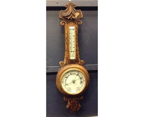 VICTORIAN WHEEL BAROMETER AND THERMOMETER
with opaque glass dials, contained in carved oak case, 90cm high