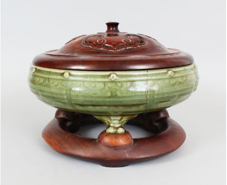 A LARGE CHINESE MING DYNASTY LONGQUAN CELADON STONEWARE TRIPOD CENSER, together with a fitted carved hardwood cover and stand