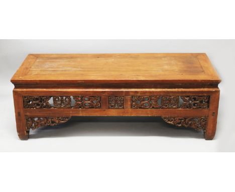 A 19TH/20TH CENTURY CHINESE OR TIBETAN LOW RECTANGULAR TABLE, the pierced frieze carved with archaic scroll motifs, 52.75in(1