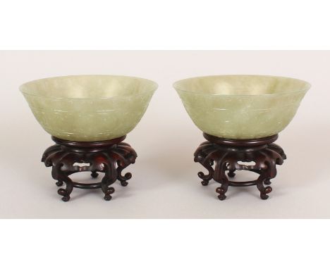 A NEAR PAIR OF GOOD QUALITY 19TH/20TH CENTURY CHINESE JADE BOWLS, with fitted carved hardwood stands, the sides of each bowl 