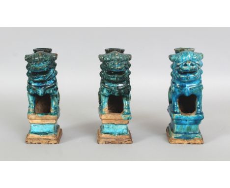 A GROUP OF THREE CHINESE MING DYNASTY TURQUOISE GLAZED STONEWARE JOSS STICK HOLDERS, each modelled in the form of a Buddhisti