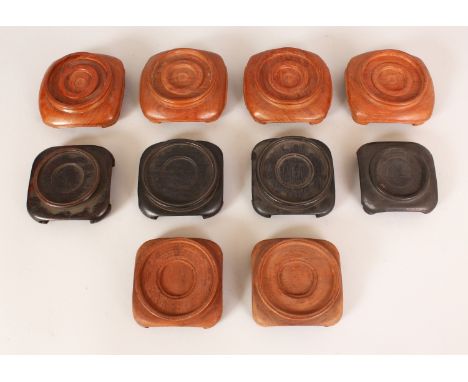 A GROUP OF TEN CHINESE CARVED HARDWOOD VASE STANDS, each of a similar design with either bracket or ruyi feet, the largest 4.