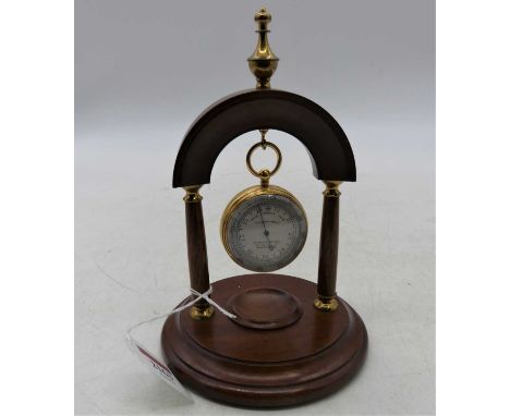 D Fraser Watson of Manchester, a brass cased compensated pocket barometer with signed silvered dial, dia. 5cm, and on mahogan