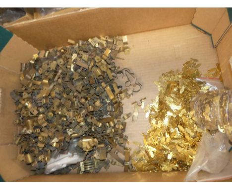 A large collection of brass thermometer tube clips together with brass door closers