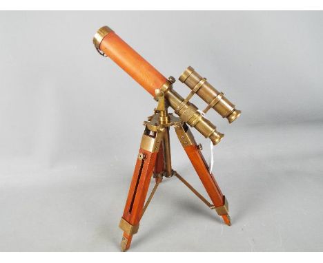 A brass and leather telescopr with sight mounted on a tripod stand