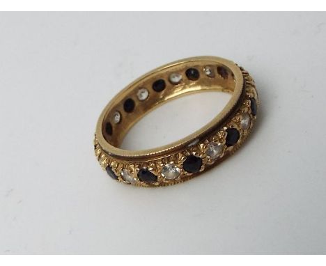 A lady's hallmarked 9 carat yellow gold eternity ring set with red and white stones, approx 2.5 gm (all in), size M + 1/2