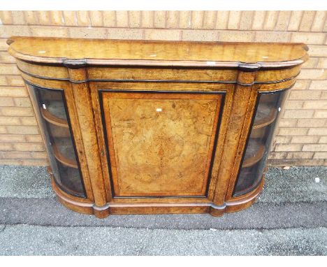 A burr walnut veneered credenza having central cupboard flanked by two glazed, twin shelf display sections and inlaid decorat