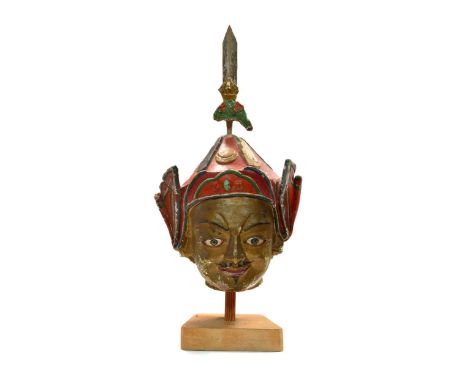 A Tibetan painted stucco head of Padmasambhava, 17th/18th century or earlier,wearing a traditional red conical hat with dorje