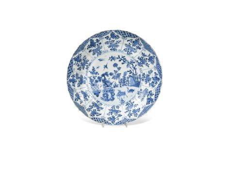 A Chinese blue and white porcelain dish, Qing Dynasty, Kangxi (1662-1722),the centre painted with birds and animals in a gard