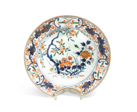 A Japanese Arita porcelain barber's bowl, 18th century,painted in underglaze blue, enamel colours and gilt with a fruiting tr
