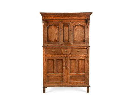 A George III oak cupboard,with a pair of shaped panel cupboard doors above three drawers and two cupboard doors below175 x 11