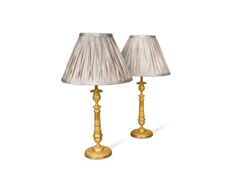 A pair of Regency engine turned ormolu candlestick lamps, circa 1820,with modern conversion to electricity40cm to top of ligh