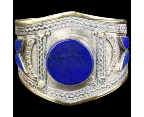 An Afghan Ethnic lapis lazuli cuff bangle, apparently unmarked, setting height 56.2mm, internal circumference approx 18cm, 43