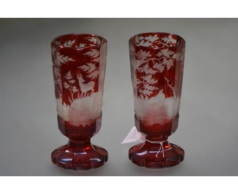 A pair of Bohemian ruby cut to clear glass vases, c. 1900, each of tapering octagonal form, the bodies decorated with stags i