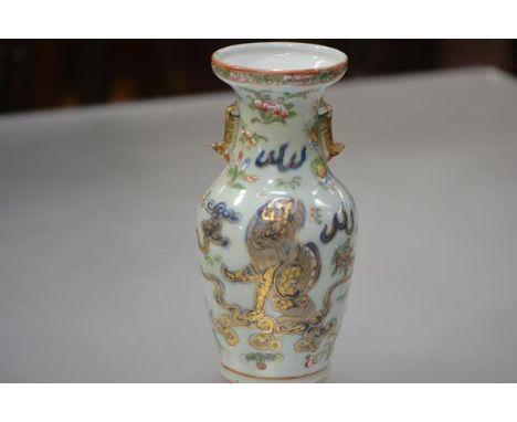 A Chinese celadon porcelain baluster vase, enamel painted with a dog of fo amidst blossoming sprigs, birds and butterflies, u