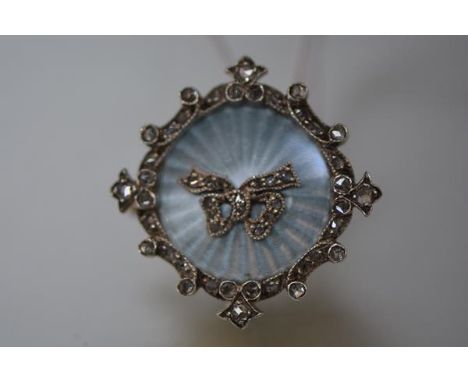 An Edwardian diamond set enamel brooch pendant, of circular form, the sky blue engine-turned enamel panel centred by a diamon