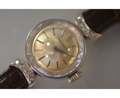 A vintage lady's Movado dress watch, the circular gilt dial with baton numerals within a white metal case (indistinctly stamp