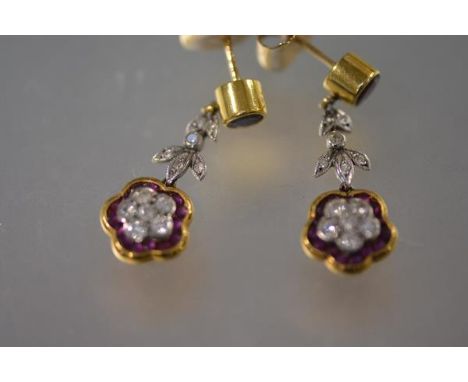 A pair of diamond and ruby drop earrings, each with round ruby stud in collet setting over a platinum spacer pave  set with d