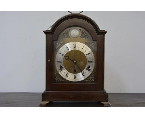 A mahogany cased bracket clock in 18th century style, by Elliott, retailed by Hamilton & Inches, the arched case enclosing a 