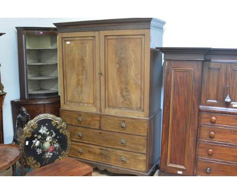 A George III mahogany linen press, with dentil carved cornice above a band of blind fretwork, over a pair of doors enclosing 