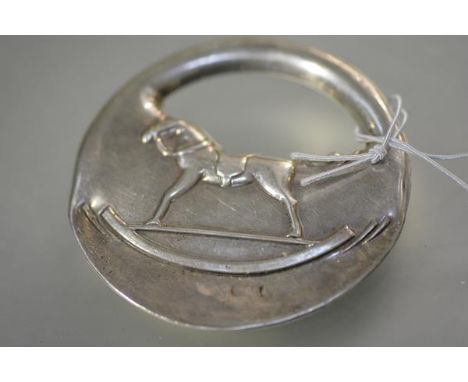 Hermes, a sterling silver rattle, of padlock form, repousse with a rocking horse, stamped marks including 925. Diameter 7cm