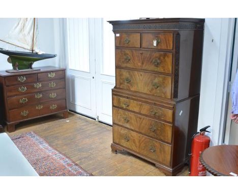 A George III style walnut chest on chest, with dentil-carved cornice above a blind fretwork frieze, over two short and two lo