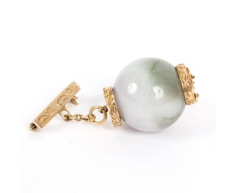 A Chinese jade and 14K gold brooch, the large circular carved jade bead with gold mounts to resemble a lantern, suspended on 