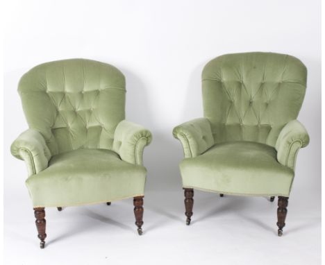A pair of Edwardian button back armchairs, on turned front legs with castors
