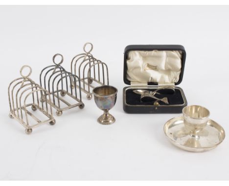 Three silver toast racks, London 1956, two silver egg cups and a cased spoon and pusher, approximately 525gm