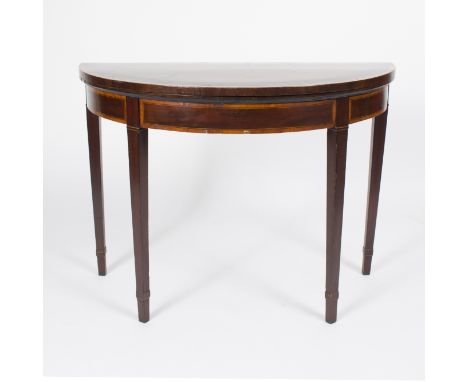 An early 19th Century mahogany half-round card table, crossbanded in satinwood, the folding top lined with green baize, on sq