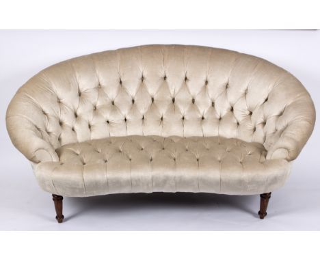 A cream upholstered button back two seater settee, on turned front legs