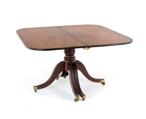 A George III mahogany two-pillar dining table in the form of a breakfast table extending to include a central leaf, the centr