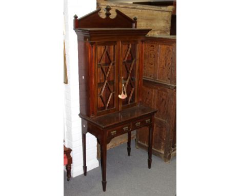 An Edwardian mahogany display cabinet, the key with Gillows label, the broken architectural pediment above glazed doors, the 