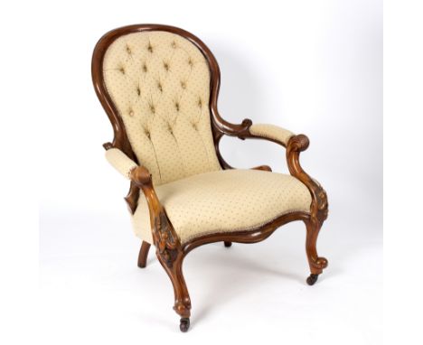 A Victorian walnut armchair with padded scroll arms, deep button back and upholstered seat on moulded cabriole legs