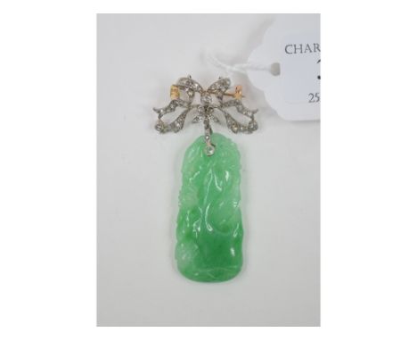 A carved jade brooch, on a ribbon tie suspension