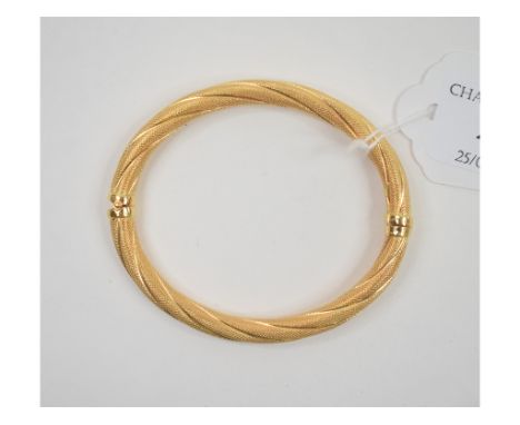 An 18ct gold bangle, with textured decoration, approx. 13.9 g