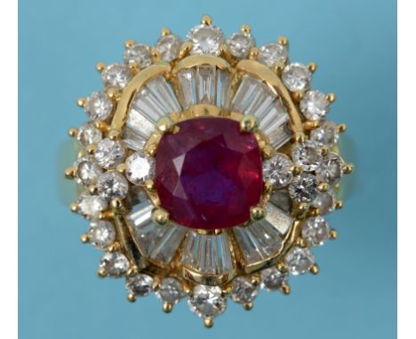 An 18ct gold, ruby and diamond cluster ring, the central cushion cut ruby surrounded by baguette and brilliant cut diamonds, 
