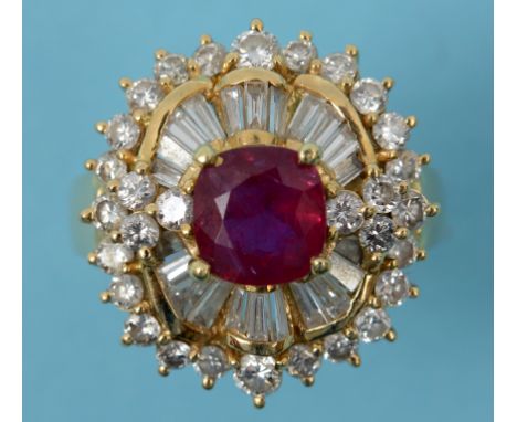 An 18ct gold, ruby and diamond cluster ring, the central cushion cut ruby surrounded by baguette and brilliant cut diamonds, 