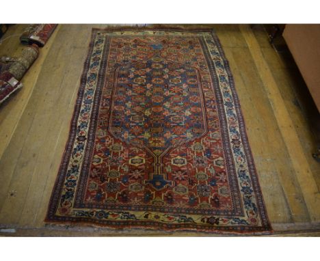 An Eastern rug, decorated floral motifs with a central lozenge on a blue ground, within a multi border, 219 x 133 cm Conditio