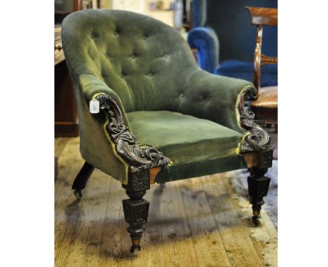 An early Victorian button back armchair, with carved arms and legs