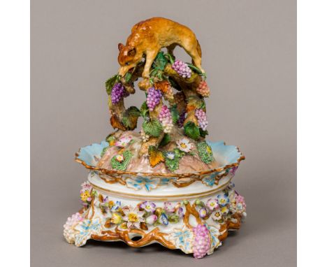 A 19th century Meissen porcelain lidded desk stand, the removable cover decorated with fruiting vines beneath a fox form fini