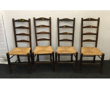 A set of four rush seated oak ladder back chairs