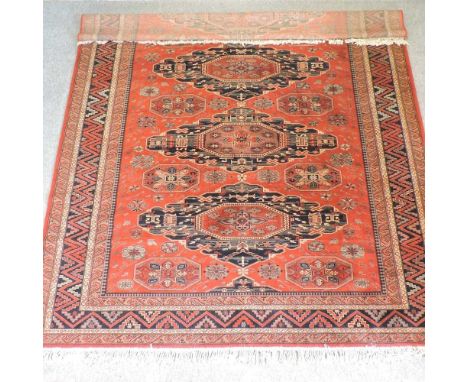 A Turkish carpet, with three central medallions, on a red ground360 x 270cm