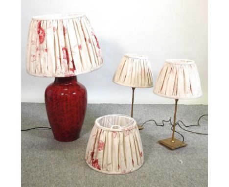 A large red pottery table lamp and shade, 75cm high, together with a pair of gilt metal table lamps and shades and a matching