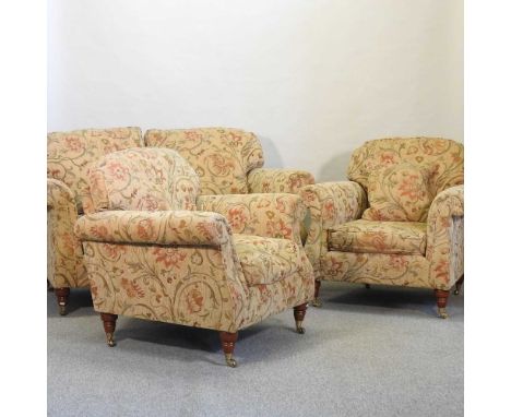 A modern floral upholstered two seater sofa, together with a pair of matching armchairs, on turned legs and casters (3)160w x