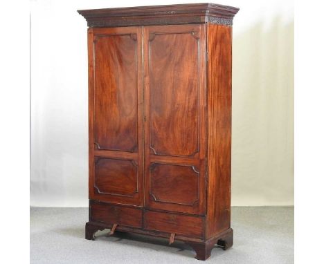 A George III mahogany double wardrobe, with a Greek key moulded and fret carved cornice, containing a pair of doors over two 